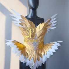 a black mannequin with gold and white wings