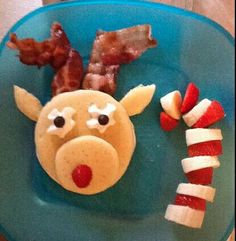 a blue plate topped with fruit and vegetables covered in animals'nose shaped food items