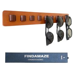 a wooden rack with sunglasses hanging from it's sides next to a pair of glasses