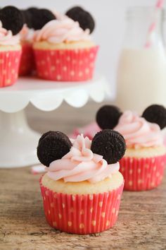 three cupcakes with frosting and mickey ears on top are sitting on a table