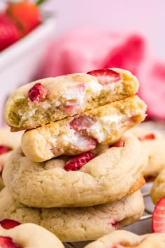 strawberry shortbread cookies stacked on top of each other with one bite taken out of the cookie