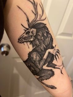 a person with a tattoo on their arm that has a deer skull and antlers on it