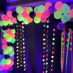 balloons and streamers are hanging from the ceiling in front of an arch decorated with stars