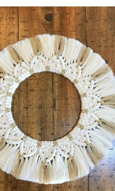 a white wreath with tassels on a wooden floor