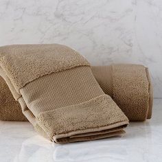 two towels folded on top of each other in front of a white marble countertop