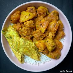 a white plate topped with chicken and rice next to tortilla chips on top of a table