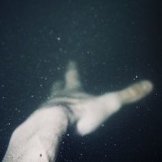 a person's hand is seen through the water