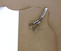 a pair of scissors sitting on top of a piece of paper