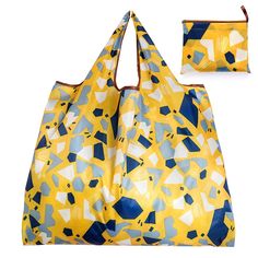 a large yellow and blue bag next to a small purse on a white background,