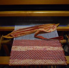 a close up of a weaving machine with red and white material on it's sides