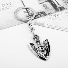 a close up of a metal object on a key chain with a card in the background