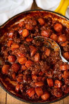 a bowl filled with chili and beans on top of a wooden table