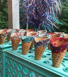 ice cream cones with sprinkles are lined up on a table