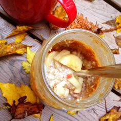 a jar filled with oatmeal sitting on top of a wooden table next to leaves