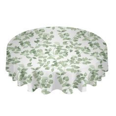 a round tablecloth with green leaves on the top and white base, in front of a white background