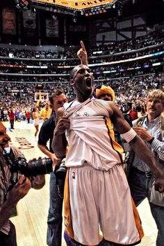 a basketball player is holding his arms in the air