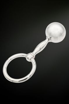 a metal object with a white ball on it's end and a black background