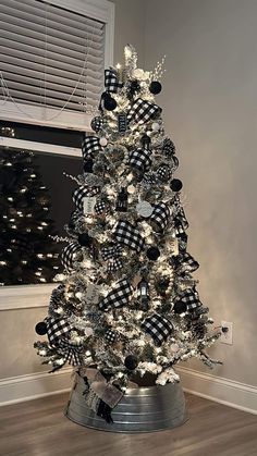 Frosted Christmas tree with black sparkly ornaments, mini lanterns, Buffalo print ribbon and metal tree collars Black White And Gray Christmas Tree, Black And White Vintage Christmas Tree, Black White Buffalo Plaid Christmas Tree, Buffalo Tree Christmas, Buffalo Theme Christmas Tree, Black And White Flocked Tree, Buffalo Black And White Christmas Tree, Back And White Christmas Tree, Black And White Tree Ornaments