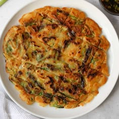 a white plate topped with an omelet covered in cheese