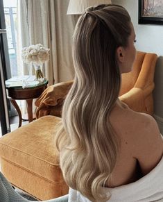 a woman with long blonde hair sitting in a chair