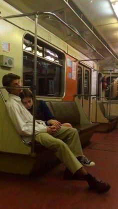 two people sitting on a subway train next to each other