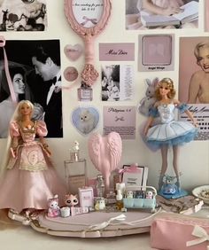 there are many barbies on the table with pictures all over it and in front of them is a teddy bear