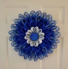 a blue and silver flower on a white door