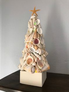 a small christmas tree made out of seashells