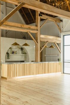 an empty room with wooden floors and beams