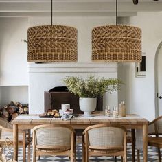 a dining room table with chairs and a potted plant next to the fire place