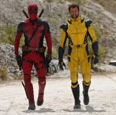 two men in deadpool costumes walking down a dirt road