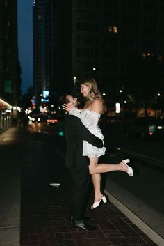 a man and woman are dancing on the sidewalk