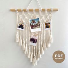 a white wall hanging with pictures and tassels attached to the side of it