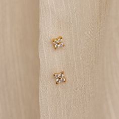 Our Diamond Ivy Flower Studs are the ultimate versatile accessory, easily styled for everyday flair or as an extra romantic touch to your wedding attire. Whether you're running errands or saying "I do," these earrings add a hint of sparkle and charm to any look, making them a must-have staple for any occasion! SKU: RR-ER364 Product Details Material: High Quality Solid 925 Sterling Silver Finish: 18K Gold ∙ Sterling Silver Featuring ~5mm Diamond CZ Flower Stud Earrings with ~1.5mm gemstones Sold Tiny Gold Elegant Diamond Earrings, Elegant Gold Diamond Earrings, Elegant Tiny Earrings For Wedding, Elegant Tiny Cubic Zirconia Earrings, Dainty Gold Cluster Earrings, Dainty 14k Gold Flower Earrings For Wedding, Dainty Flower Earrings For Formal Occasions, Dainty Yellow Gold Flower Earrings For Wedding, Dainty Yellow Gold Bridal Earrings