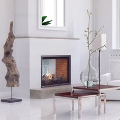 a living room with a fire place and white furniture