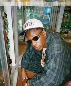 a man wearing sunglasses and a hat is looking at something in a store display case