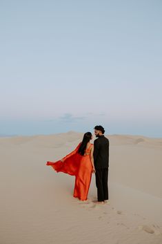 a man and woman standing in the desert