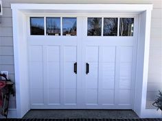 a white garage door with three windows