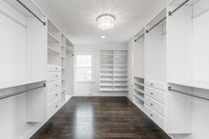 an empty walk - in closet with white cabinets and shelves