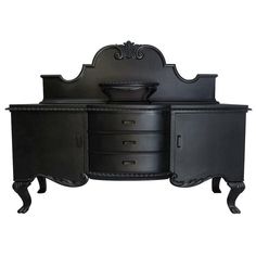 an ornate black dresser with drawers and two doors