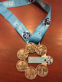 a medal with six medals attached to it on top of a wooden table next to a blue ribbon