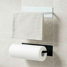 a white towel hanging on the wall next to a roll of toilet paper