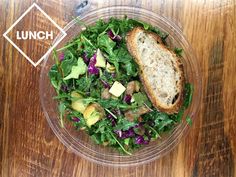 a salad in a plastic bowl on top of a wooden table