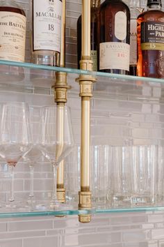 wine glasses and liquor bottles are lined up on the shelves