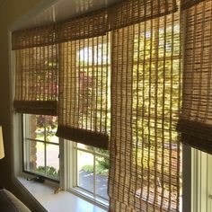 a living room with two windows covered in bamboo blinds