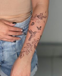 a woman's arm with a humming tattoo on the left side of her body