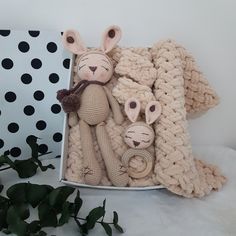 two stuffed animals are in a box on a table next to a plant and polka dot wallpaper