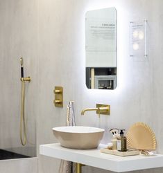 a white sink sitting under a mirror next to a faucet in a bathroom