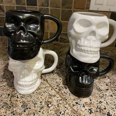 two skull mugs sitting on top of a counter