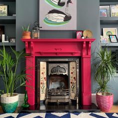 a living room with a fire place and potted plants on the floor next to it